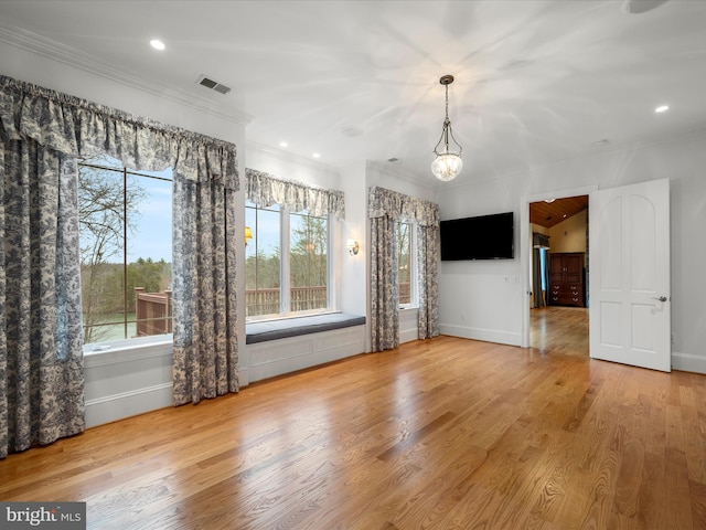 interior space featuring crown molding, wood finished floors, visible vents, and baseboards