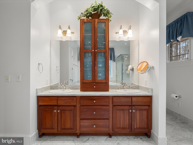 bathroom with double vanity, marble finish floor, baseboards, and a sink