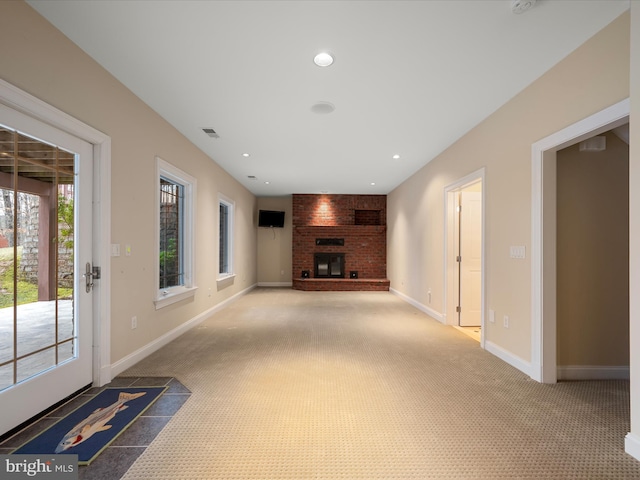 unfurnished living room featuring a fireplace, visible vents, carpet floors, and baseboards