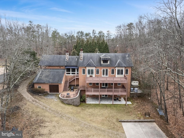 rear view of house with a patio area, a lawn, a chimney, and a deck