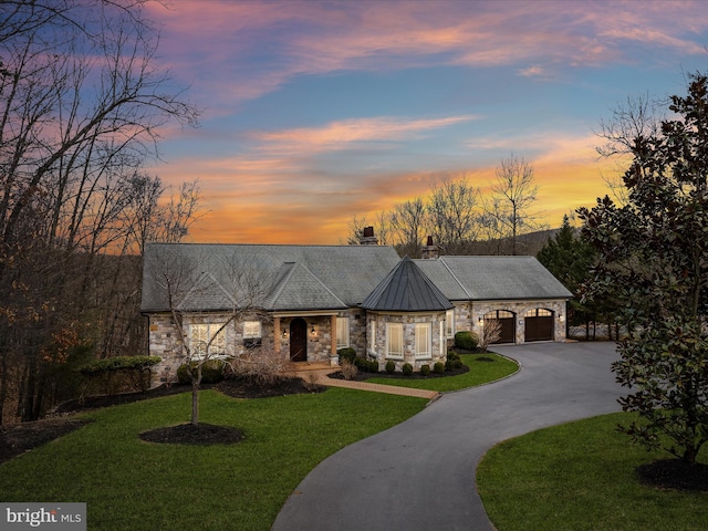 view of front of property with a front yard, a standing seam roof, a chimney, stone siding, and metal roof