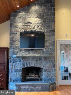 room details featuring wood finished floors, a stone fireplace, and wooden ceiling