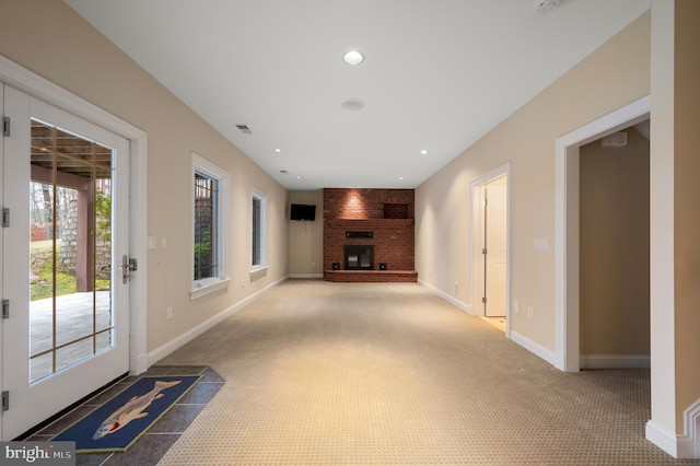 unfurnished living room with visible vents, baseboards, recessed lighting, a fireplace, and carpet flooring