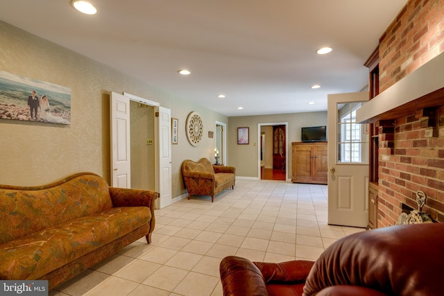 living room featuring light tile patterned flooring, recessed lighting, baseboards, and brick wall