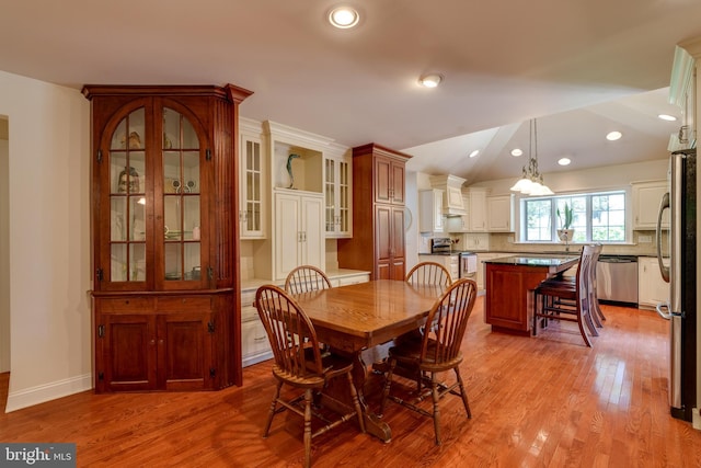 dining area featuring lofted ceiling, light wood-style flooring, recessed lighting, and baseboards