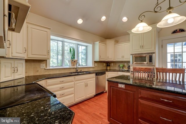 kitchen with a sink, stainless steel appliances, plenty of natural light, and light wood-style flooring