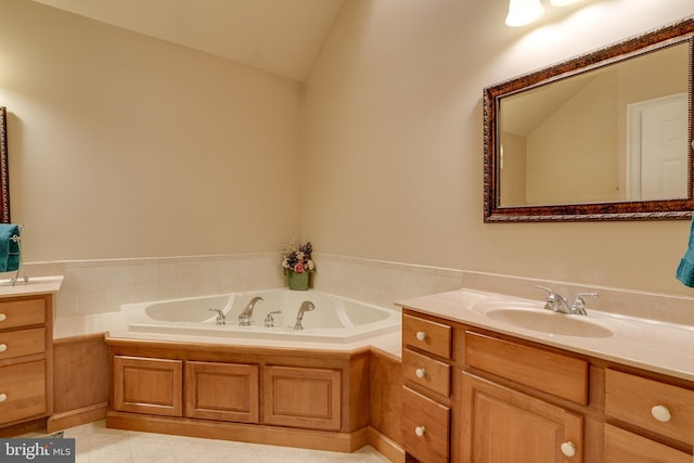 bathroom featuring a bath, tile patterned floors, vanity, and vaulted ceiling