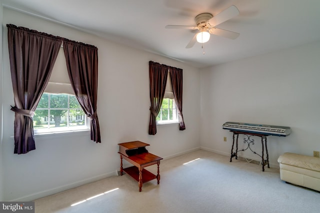 sitting room with carpet flooring, a ceiling fan, and baseboards