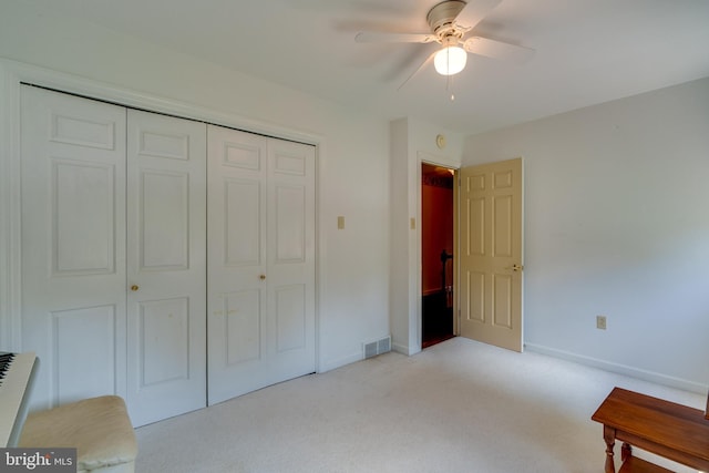 bedroom with a ceiling fan, visible vents, baseboards, a closet, and light colored carpet