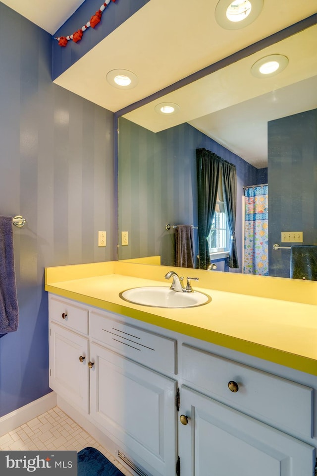 bathroom featuring recessed lighting, baseboards, vanity, and wallpapered walls