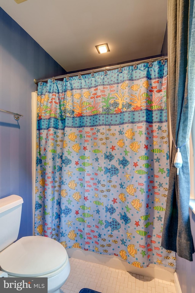 bathroom featuring tile patterned floors, a shower with curtain, and toilet