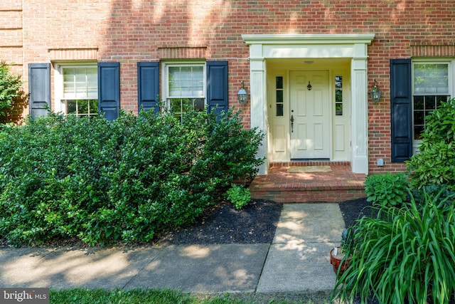 view of exterior entry featuring brick siding