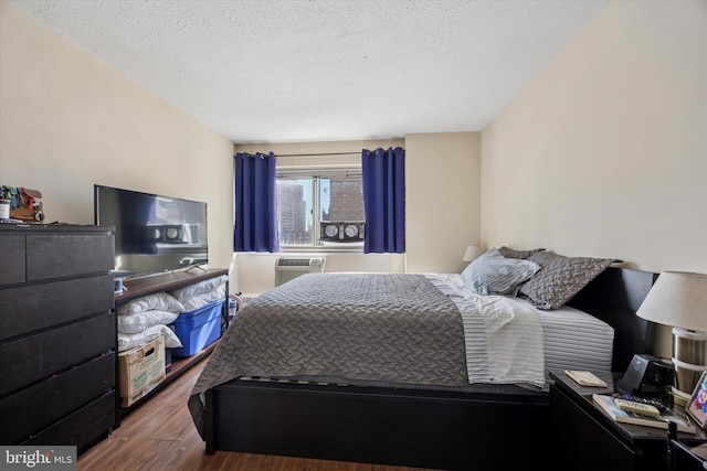 bedroom with a textured ceiling and wood finished floors