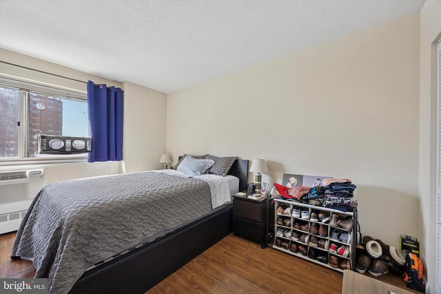 bedroom with a textured ceiling and wood finished floors