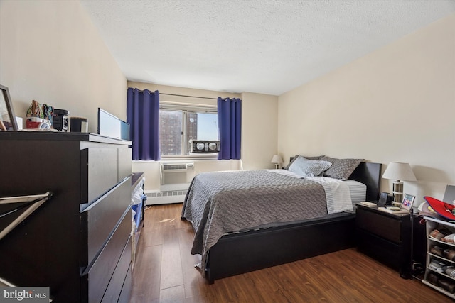 bedroom with a textured ceiling and dark wood-style flooring