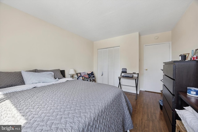 bedroom with dark wood finished floors, baseboards, and a closet