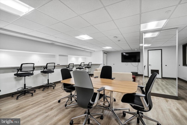 office featuring a drop ceiling, baseboards, and wood finished floors