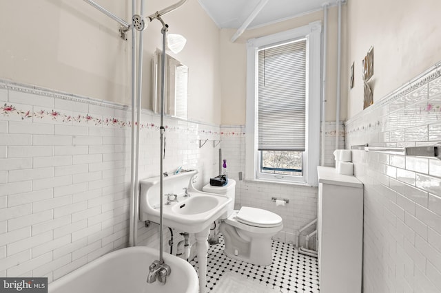 full bath featuring tile patterned floors, a wainscoted wall, toilet, and tile walls