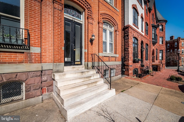 view of exterior entry featuring brick siding