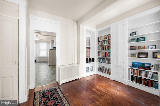 living area featuring a ceiling fan, hardwood / wood-style flooring, radiator, and radiator heating unit