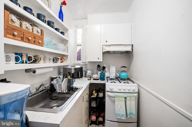 kitchen with white range with gas cooktop, under cabinet range hood, open shelves, a sink, and white cabinets