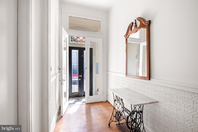 hall featuring a wainscoted wall and light wood-type flooring