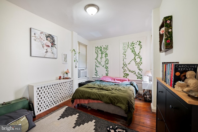 bedroom with hardwood / wood-style flooring and radiator