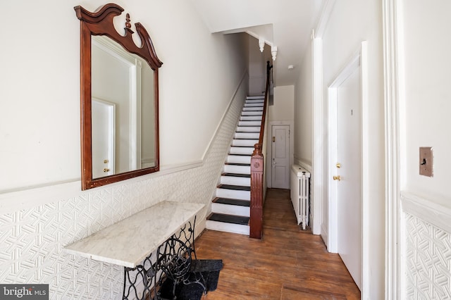 stairway with radiator and wood finished floors