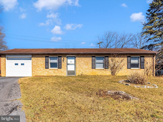 single story home featuring a front yard, brick siding, a garage, and driveway