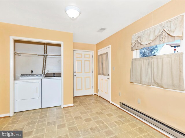 laundry area with a baseboard radiator, baseboards, independent washer and dryer, and visible vents