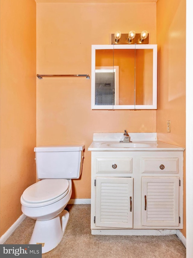 bathroom with vanity, toilet, and baseboards