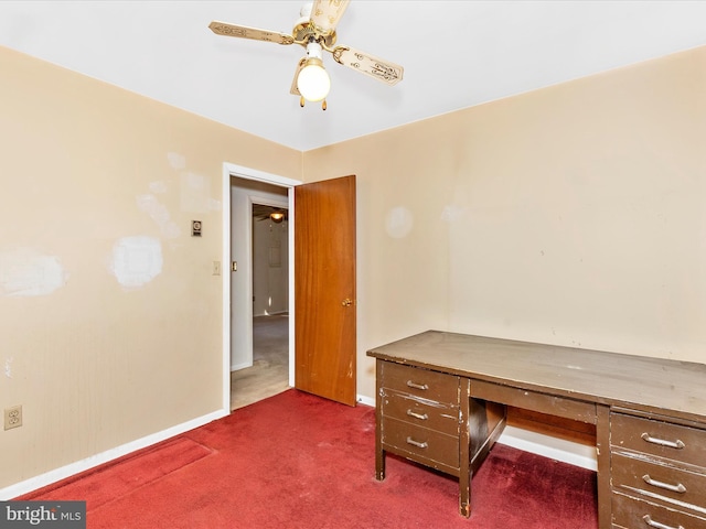 unfurnished office featuring dark carpet, baseboards, and ceiling fan