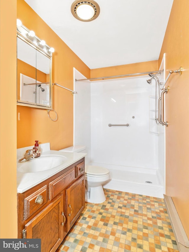 bathroom featuring a shower, toilet, and vanity