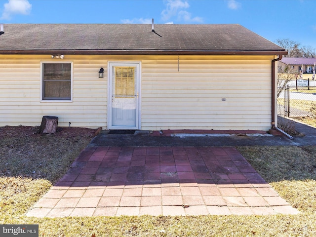 exterior space with a patio, fence, and a shingled roof