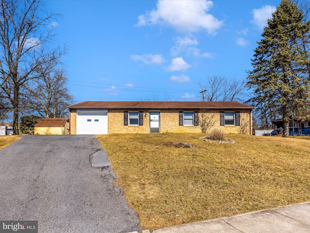 ranch-style home with a front yard, brick siding, a garage, and driveway