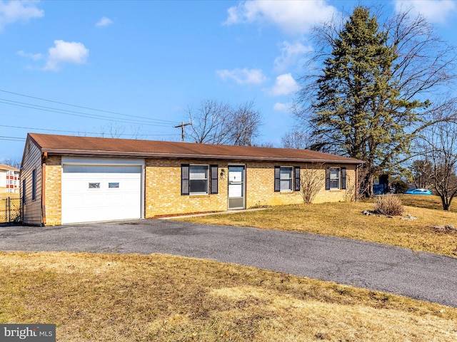 ranch-style house with a garage, a front yard, brick siding, and driveway