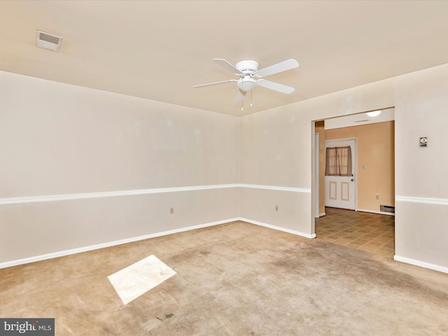 spare room with visible vents, a baseboard heating unit, carpet, baseboards, and ceiling fan