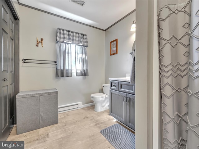 bathroom featuring visible vents, toilet, ornamental molding, baseboard heating, and wood finished floors