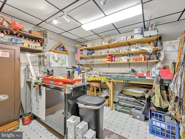 interior space with track lighting, a workshop area, and a drop ceiling