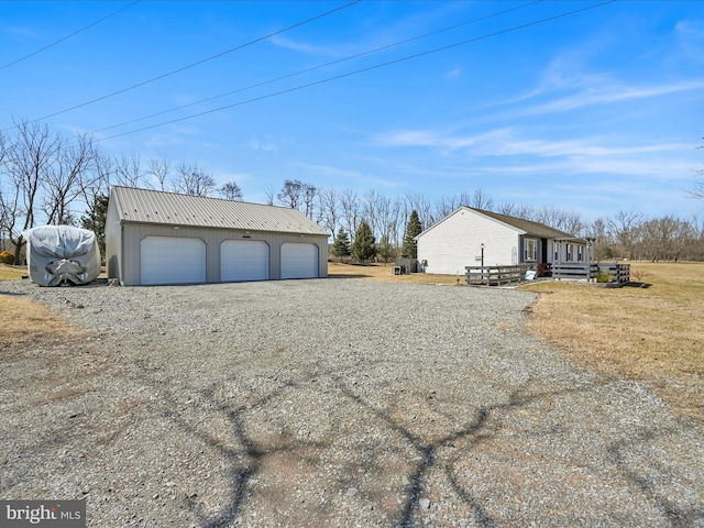 view of home's exterior with an outbuilding, metal roof, and a garage