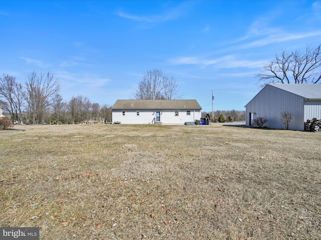 rear view of property featuring an outbuilding and a lawn