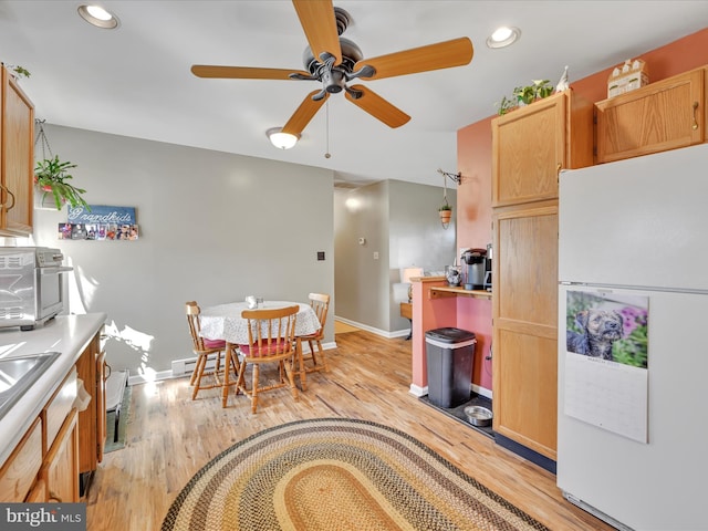 kitchen featuring baseboards, a baseboard radiator, recessed lighting, freestanding refrigerator, and light wood-style floors