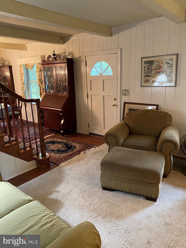 foyer entrance with beamed ceiling, stairway, and wood finished floors