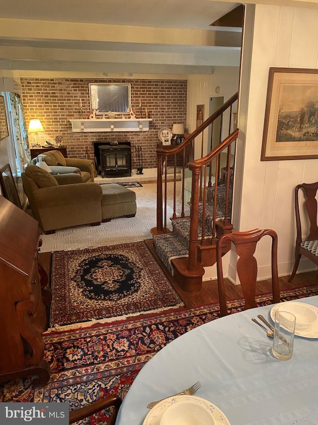 living room with stairway, wood finished floors, and brick wall