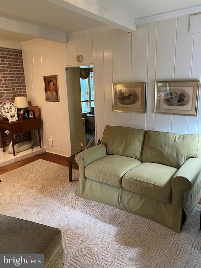 living area featuring beamed ceiling and wood finished floors