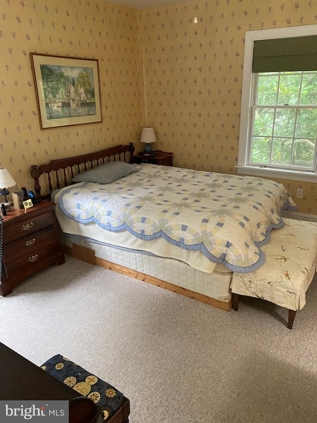 bedroom with wallpapered walls and carpet floors