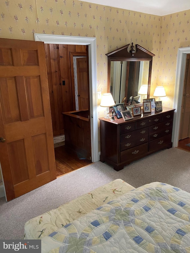 bedroom featuring light colored carpet and wallpapered walls