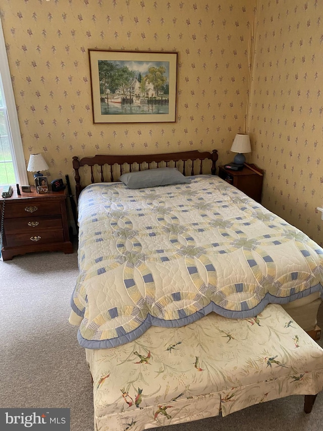 bedroom with wallpapered walls and carpet flooring