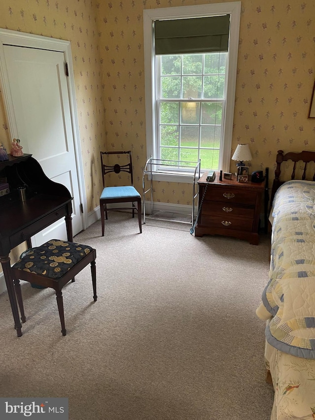 bedroom with light colored carpet, wallpapered walls, and baseboards