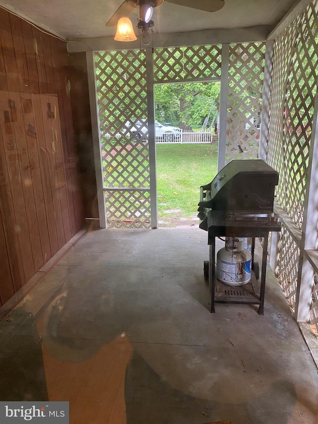 misc room with unfinished concrete flooring and wood walls